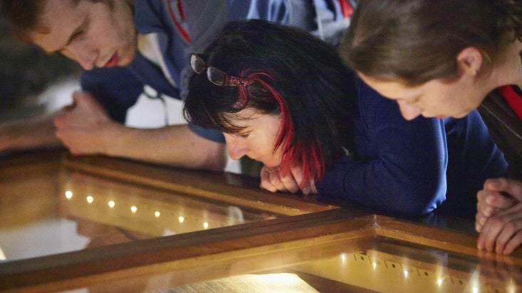 Visitors looking at a display case at Ty Mawr Wybrnant, birthplace of Bishop William Morgan in Conwy, Wales